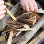 Laying firelight kindling on top of charcoal wood